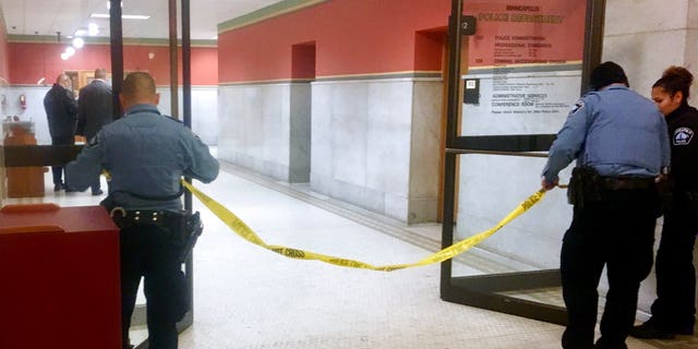 Police set up crime scene tape outside a Minneapolis police room at Minneapolis City Hall on Monday, Dec. 18, 2017. Minneapolis police say their officers have been involved in a shooting inside the department's investigative unit at City Hall. (AP Photo/Jeff Baenen)
