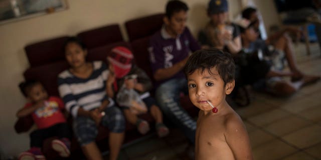 Several hundred immigrants, mostly women and children, are staying in temporary tents set up for them in a Tijuana shelter. They are expected to start trying to enter the U.S. on Sunday.