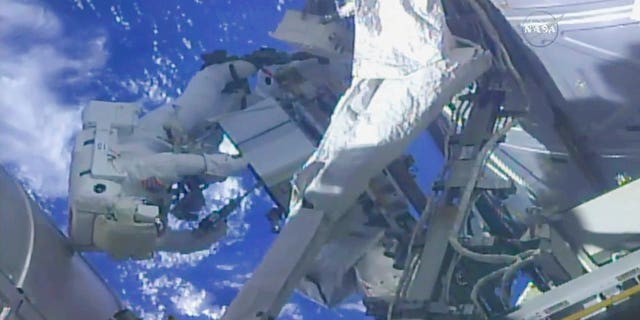 In this frame from NASA TV, NASA astronaut Ricky Arnold, left, and NASA astronaut Drew Feustel work on shuffling around a couple of space station pumps at the International Space Station on Wednesday, May 16, 2018. (NASA TV via AP)