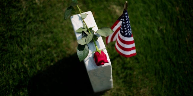 A rose sits on a tombstone of a civl war soldier at Marietta National Cemetery on Memorial Day, Monday, May 26, 2014, in Marietta, Ga. (AP Photo/David Goldman)