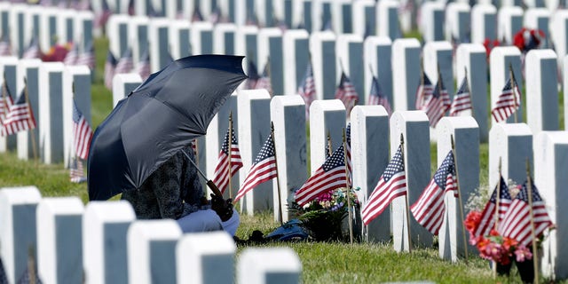 FILE -- Paulette Little visits the grave of her late husband George Little, a Navy veteran, during Memorial Day observances at the Sacramento Valley National Cemetery.