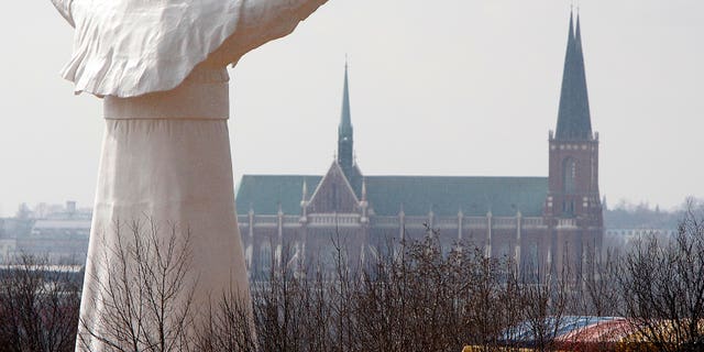 The sculpture of the late Pope John Paul II during the unveiling ceremony in Czestochowa, Poland, on Saturday, April 13, 2013. Archbishop Waclaw Depo unveiled the 13.8-meter (45.3-foot) white fiberglass figure that was funded by a businessman, Leszek Lyson, in gratitude for what he believes was an intervention by the late pontiff in saving his drowning son. (AP Photo/Czarek Sokolowski)