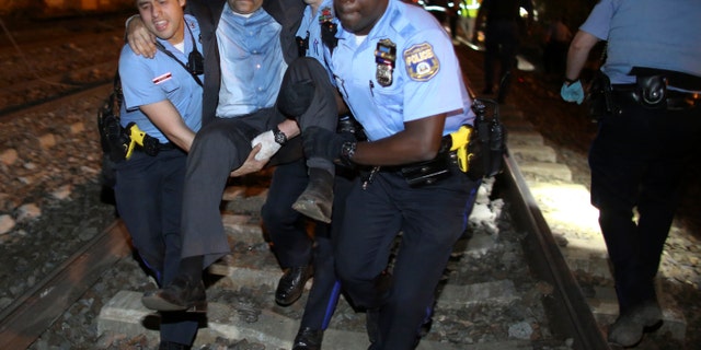 Emergency personnel help a passenger at the scene of the train wreck