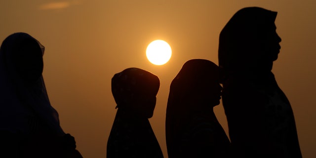 Indonesian Muslim women walk before Eid al-Fitr prayer that marks the end of the holy fasting month of Ramadan in Jakarta, Indonesia, Thursday, Aug. 8, 2013. (AP Photo/Achmad Ibrahim)