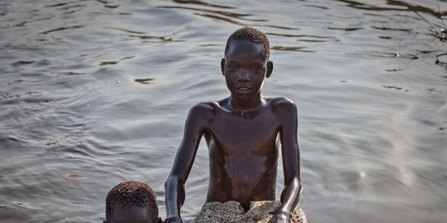 Young displaced boys bathe in a reservoir inside one of the camps for people who have fled the recent violence, in the capital Juba, South Sudan. (AP Photo/Mackenzie Knowles-Coursin)