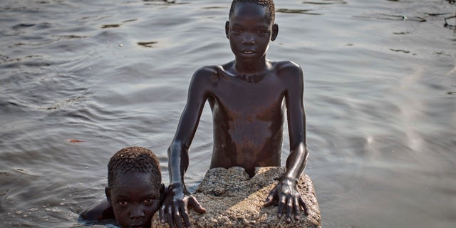 Young displaced boys bathe in a reservoir inside one of the camps for people who have fled the recent violence, in the capital Juba, South Sudan Saturday, Jan. 11, 2014. South Sudanese government troops on Friday retook Bentiu, the capital of oil-producing Unity state, from rebels loyal to the country's former vice president, a military spokesman said, while hundreds of thousands remain displaced in the nearly monthlong conflict. (AP Photo/Mackenzie Knowles-Coursin)