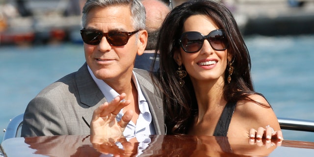 George Clooney, left, and Amal Alamuddin arrive in Venice, Italy, Friday, Sept. 26, 2014.