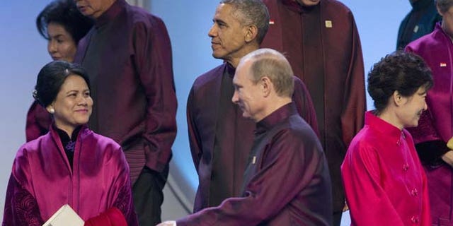 This Monday, Nov. 10, 2014 photo shows Russian President Vladimir Putin and President Barack Obama during the Asia-Pacific Economic Cooperation (APEC) Summit family photo in Beijing.