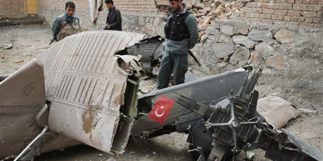 March 16, 2012: An Afghan policemen looks at the wreckage from a crashed Turkish helicopter on the outskirts of Kabul.