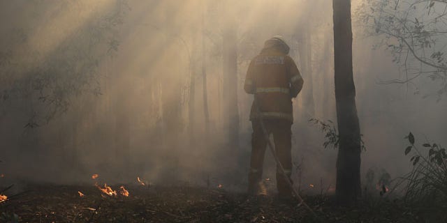 October 23, 2013: A firefighter mops up after a firestorm swept through a property in Bilpin, 47 miles from Sydney, Australia (AP Photo)