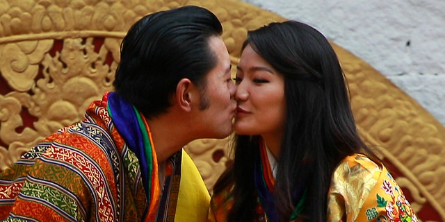 Bhutan's King Jigme Khesar Namgyal Wangchuck, left, and Queen Jetsun Pema kiss in front of the crowd at the main stadium as part of their wedding celebrations in Thimphu, Bhutan, Saturday, Oct. 15, 2011.