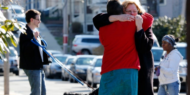 Neighbors hug outside the home of the Richard family in the Dorchester neighborhood of Boston, Tuesday, April 16, 2013. Martin Richard, 8, was killed in Monday's bombing at the finish line of the Boston Marathon.