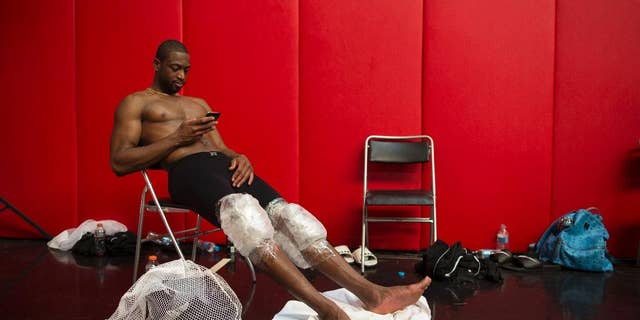 Miami Heat's Dwyane Wade rests with his knees wrapped in ice packs after practice in Rio de Janeiro, Brazil, Friday, Oct. 10, 2014. Miami Heat will play Cleveland Cavaliers in a pre-season game on Saturday as part of the NBA Global Games. (AP Photo/Felipe Dana)