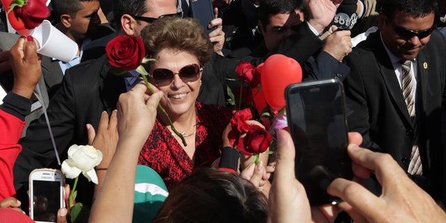 Brazil's impeached President Dilma Rousseff receives flowers from supporters as she leaves the presidential residence, on Sept. 6, 2016.