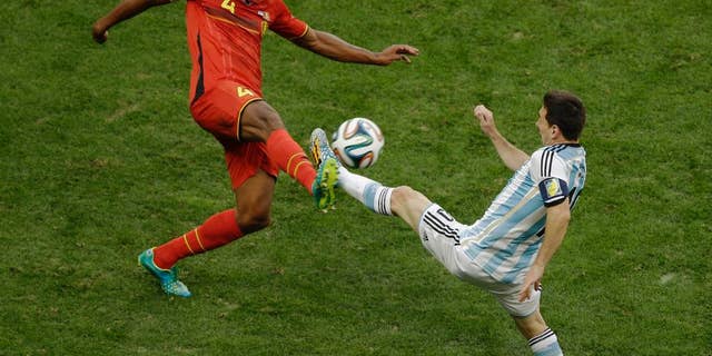 Belgium's Vincent Kompany, left, and Argentina's Lionel Messi fight for the ball during the World Cup quarterfinal soccer match between Argentina and Belgium at the Estadio Nacional in Brasilia, Brazil, Saturday, July 5, 2014. (AP Photo/Thanassis Stavrakis)