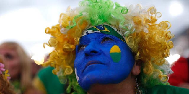 A fan of the Brazil national soccer team watches a live broadcast of the World Cup third-place soccer match between Brazil and Netherlands, inside the FIFA Fan Fest area on Copacabana beach, in Rio de Janeiro, Brazil, Saturday, July 12, 2014. (AP Photo/Silvia Izquierdo)