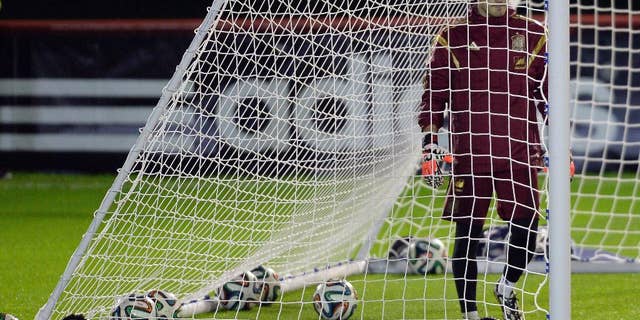 Spain's goalkeeper Iker Casillas stands surrounded by balls inside the goal during a training session at the Atletico Paranaense training center in Curitiba, Brazil, Thursday, June 19, 2014. A 2-0 loss to Chile on Wednesday left Spain without hope of advancing to the second round, becoming the first defending champion to be assured of elimination after just two group games. Spain will play its last Group A match on Monday against Australia.(AP Photo/Manu Fernandez)