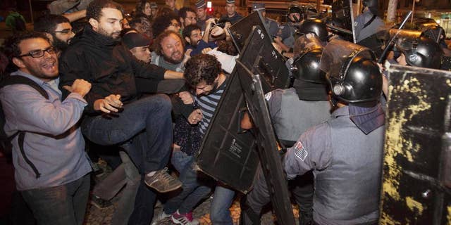 Subway train operators, along with activists from social movements, clash with riot police in front of the Ana Rosa metro station, in an ongoing subway strike, in Sao Paulo, Brazil, Monday, June 9, 2014. Authorities are deeply worried about the strike because the subway is the main means of transportation for World Cup fans scheduled to attend Thursday's opening match when Brazil takes on Croatia. The stadium is about 20 kilometers (12 miles) east of central Sao Paulo, where most tourists stay. (AP Photo/Mario Angelo)