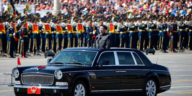 Chinese President Xi Jinping stands in a car to review the army during a parade commemorating the 70th anniversary of Japan's surrender during World War II held in front of Tiananmen Gate in Beijing, Thursday, Sept. 3, 2015. The spectacle involved more than 12,000 troops, 500 pieces of military hardware and 200 aircraft of various types, representing what military officials say is the Chinese military's most cutting-edge technology. (AP Photo/Ng Han Guan)