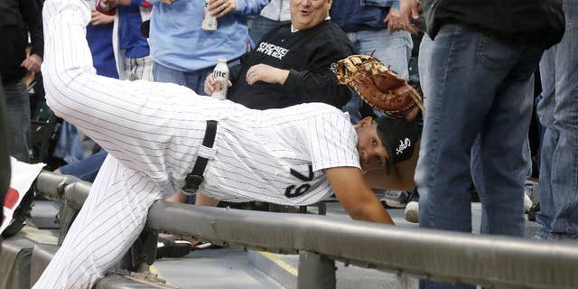 Chicago White Sox first baseman Jose Abreu shows his glove to first base umpire Marvin Hudson, after catching a fly ball off the bat of Chicago Cubs' Darwin Barney in the seats, during the second inning of an interleague baseball game Wednesday, May 7, 2014, in Chicago. (AP Photo/Charles Rex Arbogast)