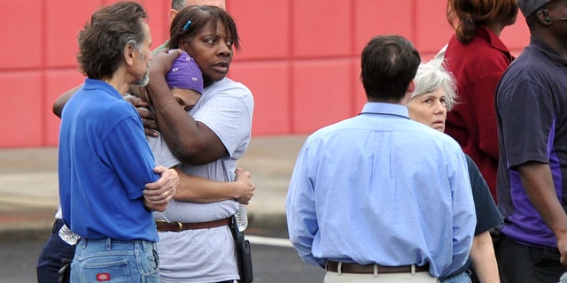 FedEx employees gather at a skating rink following a shooting at a FedEx facility in Kennesaw, Ga., on April 29, 2014.