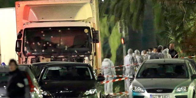 Forensic officers stand near a truck that plowed through a crowd in Nice, southern France, Friday, July 15, 2016.