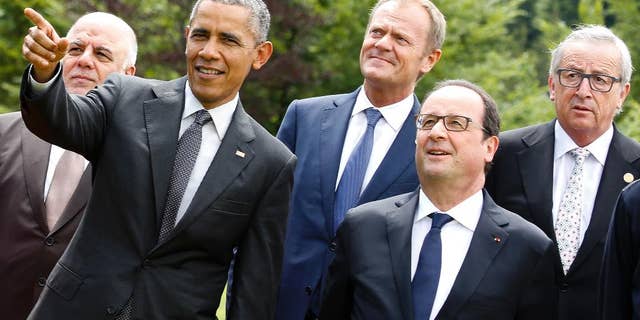 U.S. President Barack Obama, second left, points during a group photo of G-7 leaders and Outreach guests at the G-7 summit at Schloss Elmau hotel near Garmisch-Partenkirchen, southern Germany, Monday, June 8, 2015. Other leaders from left, Iraq's Prime Minister Haider al-Abadi, European Council President Donald Tusk, French President Francois Hollande and European Commission President Jean-Claude Juncker. (AP Photo/Markus Schreiber)