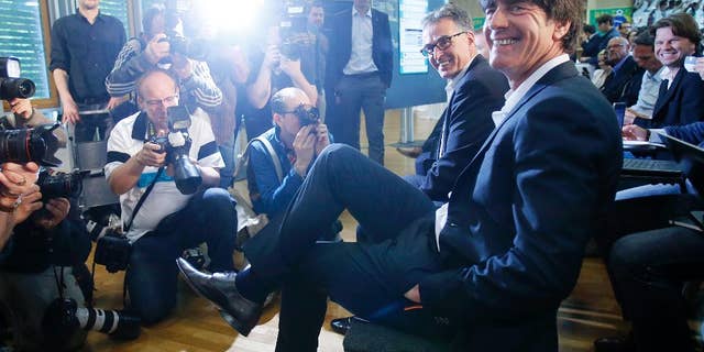 Joachim Loew, the coach of German national soccer team, smiles as he waits for the beginning of a press conference where he presented his preliminary team for the upcoming World Cup in Brazil in Frankfurt, Germany, Thursday, May 8, 2014. (AP Photo/Michael Probst)