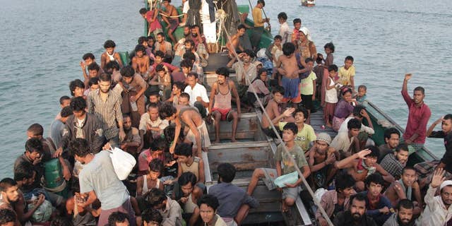 Migrants wait to be be rescued by Acehnese fishermen on their boat on the sea off East Aceh, Indonesia, Wednesday, May 20, 2015. In a potential breakthrough in Southeast Asia's humanitarian crisis, Indonesia and Malaysia offered Wednesday to provide temporary shelter to thousands of migrants stranded at sea after weeks of saying they weren't welcome. But they appealed for international help, saying the crisis was a global, not a regional, problem. (AP Photo/S. Yulinnas)