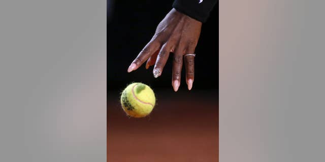 Serena Williams' hand reaches for the ball as she gets ready and serve to China's Shuai Zhang, during their match at the Italian open tennis tournament in Rome, Friday, May 16, 2014. (AP Photo/Gregorio Borgia)