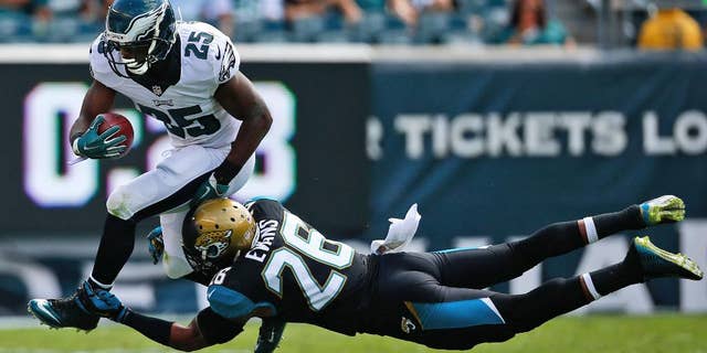 Philadelphia Eagles' LeSean McCoy, left, tries to break a tackle by Jacksonville Jaguars' Josh Evans during the first half of an NFL football game, Sunday, Sept. 7, 2014, in Philadelphia. (AP Photo/Matt Rourke)
