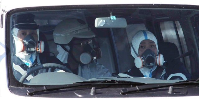 March 12: Police officers wearing gas masks patrol in the area of the Fukushima power plant's Unit 1 in Okumamachi, Fukushima Prefecture, northern Japan, amid fears that a part of the plant could meltdown after being hit by a powerful earthquake and tsunami Friday. (AP/The Yomiuri Shimbun)