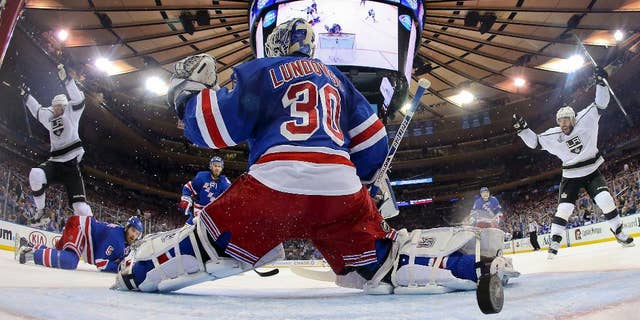Los Angeles Kings center Jeff Carter (77), left, and left wing Dwight King (74), right, react as the puck bounces off the post and into the net past New York Rangers goalie Henrik Lundqvist (30) to end the first period during Game 3 of the NHL hockey Stanley Cup Final, Monday, June 9, 2014, in New York. (AP Photo/Bruce Bennett, Pool)