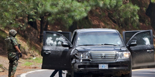 Aug. 24, 2012: An armored U.S. Embassy vehicle is checked by military personal after it was attacked by unknown assailants on the highway leading to the city of Cuernavaca, near Tres Marias, Mexico.