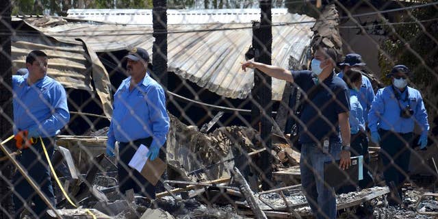 Forensics work among the rubble of a nursing home after it caught fire in Mexicali, Mexico, Tuesday, June 23, 2015. The fire killed more than a dozen elderly residents at the home, and the cause of the blaze was being investigated by the state prosecutors' office, according to Mexicali Mayor Jaime Diaz Ochoa. (AP Photo/Cristian Torres)
