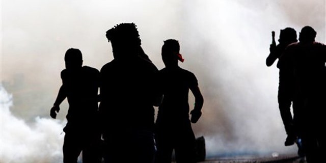 March 31, 2012: Bahraini anti-government protesters react to tear gas fired by riot police Saturday.
