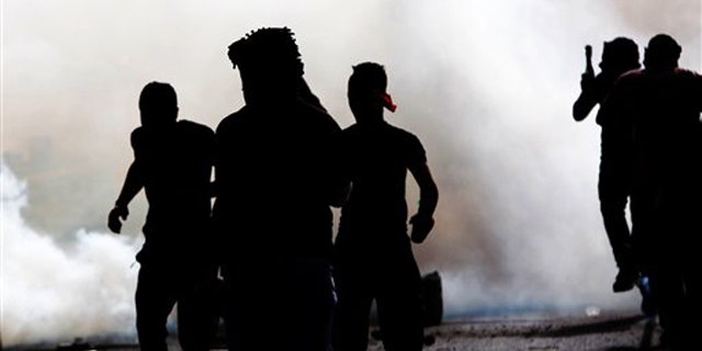 March 31, 2012: Bahraini anti-government protesters react to tear gas fired by riot police Saturday.