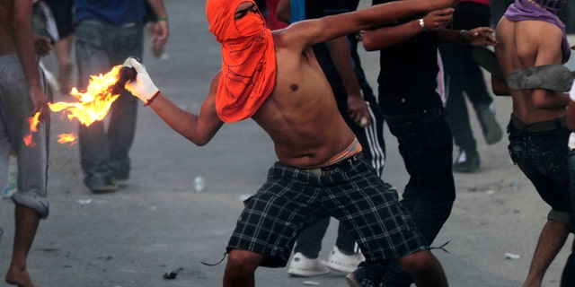 Oct. 3, 2012 - A Bahraini anti-government protester throws a petrol bomb toward riot police, unseen, firing tear gas and stun grenades in Sadad, Bahrain.
