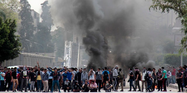 April 23, 2014: Pro-Muslim Brotherhood students block a road with burning tires and chant slogans against the police and army outside the main campus of Cairo University, in Cairo, Egypt. (AP Photo/Aly Hazzaa, El Shorouk)