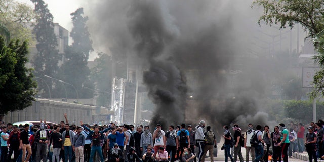 April 23, 2014: Pro-Muslim Brotherhood students block a road with burning tires and chant slogans against the police and army outside the main campus of Cairo University, in Cairo, Egypt. (AP Photo/Aly Hazzaa, El Shorouk)