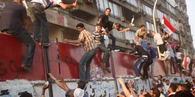 Sept. 9: Some hundreds of Egyptian activists demolish a concrete wall built around a building housing the Israeli embassy in Cairo, Egypt, to protect it against demonstrators, as they raise their national flag.