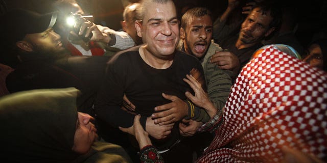 October 30, 2013: A released Palestinian prisoner, Omar Masoud, 40, center, who was arrested in May, 1993 for killing an Israeli lawyer, smiles to his mother Tamam Masoud, 70, right, upon his arrival to his family house in Shati Refugee Camp. (AP Photo)