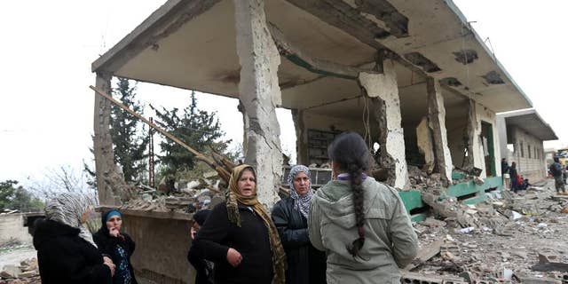 Lebanese women gather in front of damaged shops at the site of a deadly car bombing Sunday night, in the town of Nabi Othman, about 30 kilometers (18 miles) north of Baalbek, northeast Lebanon, Monday March 17, 2014. Lebanese security officials said the explosion killed at least two people and caused panic and massive destruction in the Hezbollah stronghold, which has a sizable Christian population in addition to Shiites. The civil war in neighboring Syria already has ignited polarizing sectarian tensions between Lebanon's Sunnis and Shiites. (AP Photo/Hussein Malla)