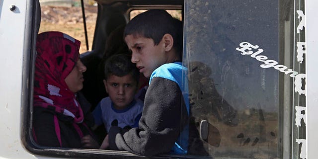 Aug. 4, 2014: A Lebanese family wait to depart in a minibus on the outskirts of Arsal, a predominantly Sunni Muslim town near the Syrian border in eastern Lebanon. (AP)