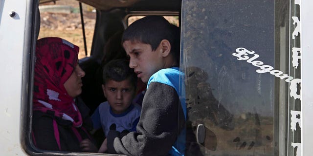 Aug. 4, 2014: A Lebanese family wait to depart in a minibus on the outskirts of Arsal, a predominantly Sunni Muslim town near the Syrian border in eastern Lebanon. (AP)
