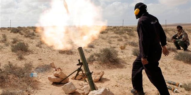 March 31: A Libyan rebel shells pro-Qaddafi forces with mortar fire, along the front line outside the eastern town of Brega, Libya. Libya conceded Thursday that Foreign Minister Moussa Koussa had resigned but claimed that it was a personal decision driven by health problems, not a sign that the embattled regime is cracking at the highest levels. (AP)