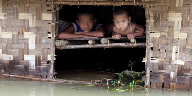 Aug. 17, 2012: Children look out from their house half-submerged in a low-lying area flooded by the Nga-Wun River in Ah-Thouk township, Ayeyarwaddy Delta, about 80 miles southwest of Yangon, Myanmar.