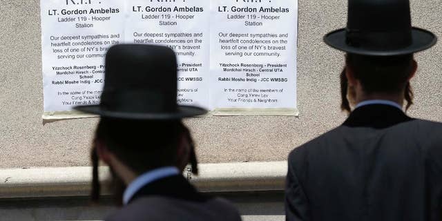 Signs commemorating Lt. Gordon Ambelas are displayed across the street from a firehouse in New York, Sunday, July 6, 2014. The Fire Department of New York is mourning the death of Ambelas, who became trapped while looking for victims in a public-housing high-rise blaze, the first to die in the line of duty in more than two years. Ambelas died Saturday after suffering multiple injuries while on the 19th floor of the 21-story building in the Williamsburg section of Brooklyn, officials said. (AP Photo/Seth Wenig)