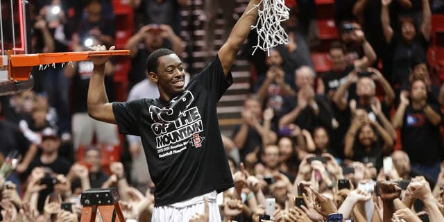 San Diego State's Xavier Thames holds up a cut net after San Diego State defeated New Mexico 51-48 to win the Mountain West Conference title, in an NCAA college basketball game Saturday, March 8, 2014, in San Diego. (AP Photo/Lenny Ignelzi)
