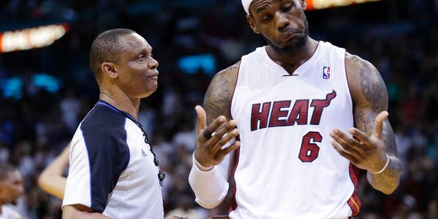 Miami Heat's LeBron James, right, reacts as he talks with official Michael Smith during the second half of an NBA basketball game against the Indiana Pacers, Friday, April 11, 2014, in Miami. The Heat defeated the Pacers 98-86. (AP Photo/Lynne Sladky)